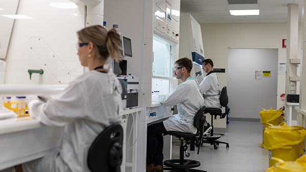 A group of scientists in a laboratory, working together on an experiment.
