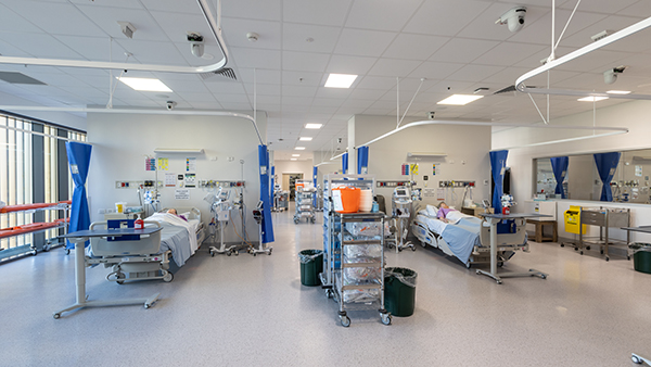 Hospital room with a bed, table, and mirror for patient care and recovery.